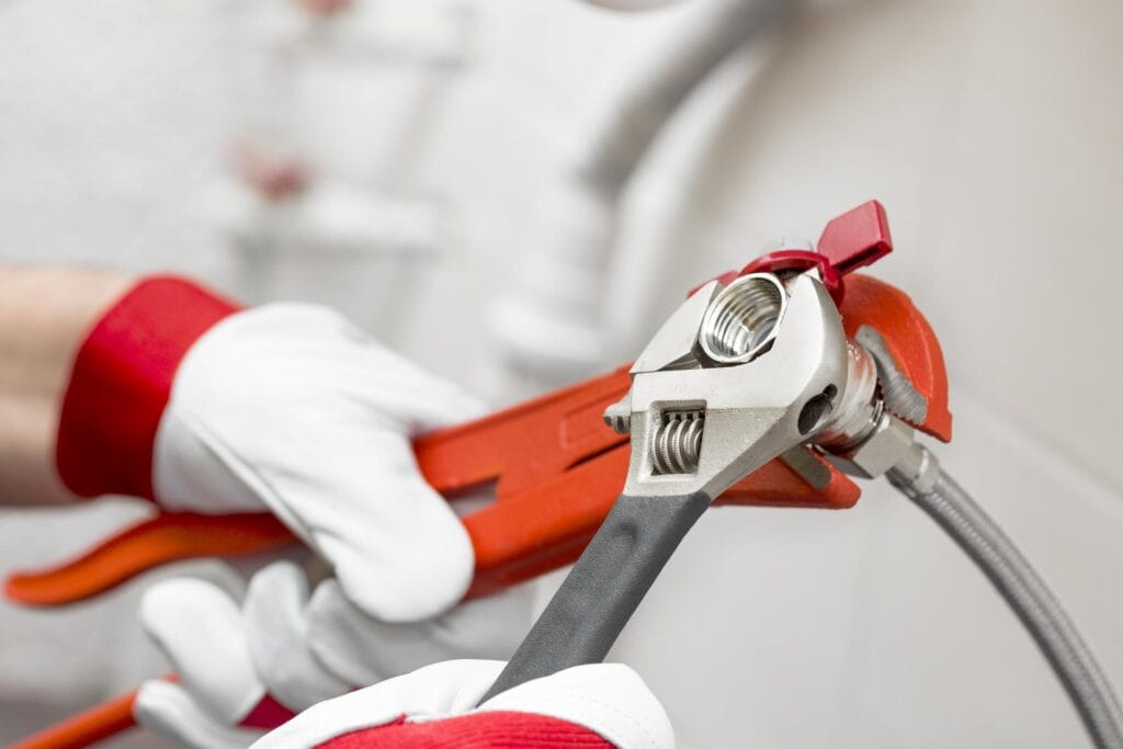 Plumber holding pipe wrenches for an emergency repair in Lynn Haven