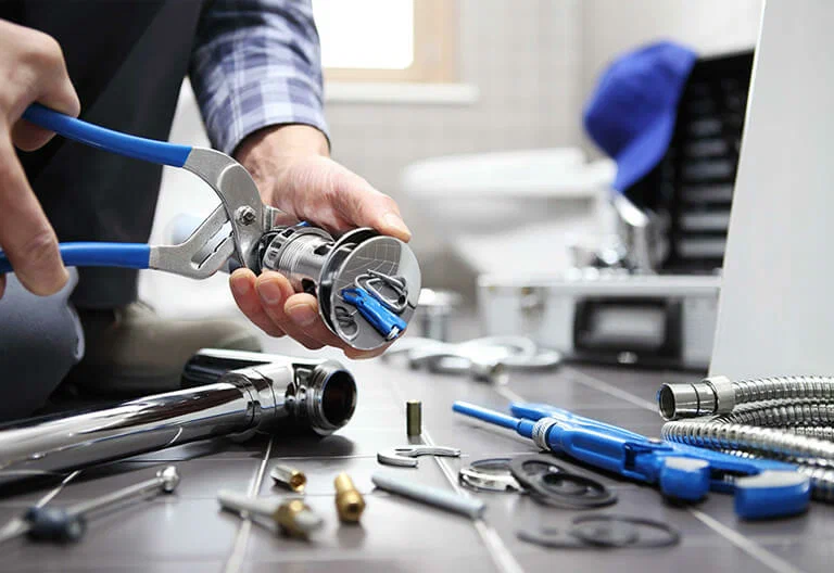 Technician repairing a plumbing fixture with professional tools in Lynn Haven