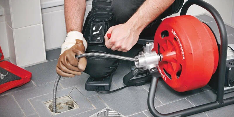 Plumber using a drain-cleaning machine in Lynn Haven