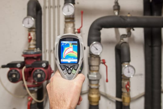 Plumber using a thermal imaging camera to inspect pipes in Lynn Haven