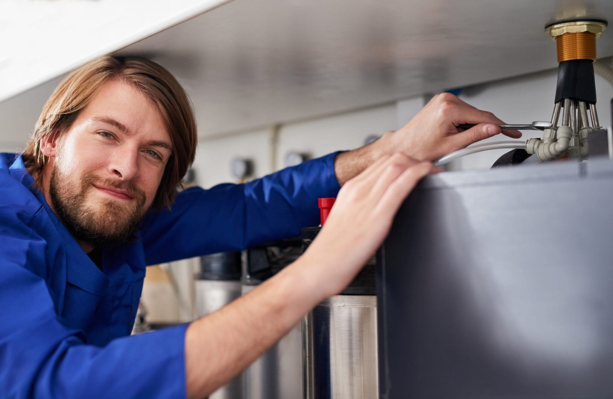 Technician servicing a residential water heater tank in Lynn Haven
